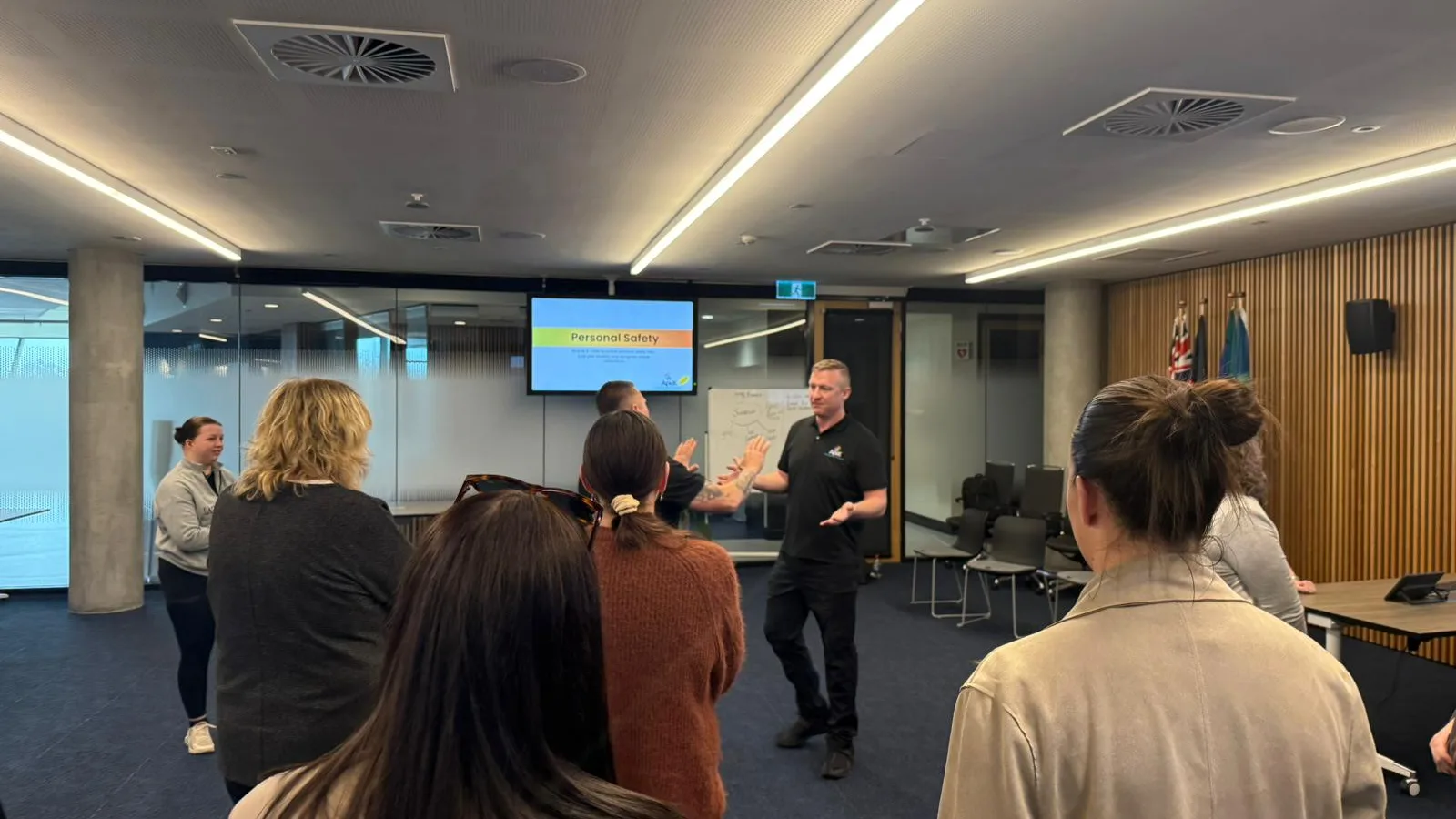 An Apex trainer talks a standing group through a personal safety session